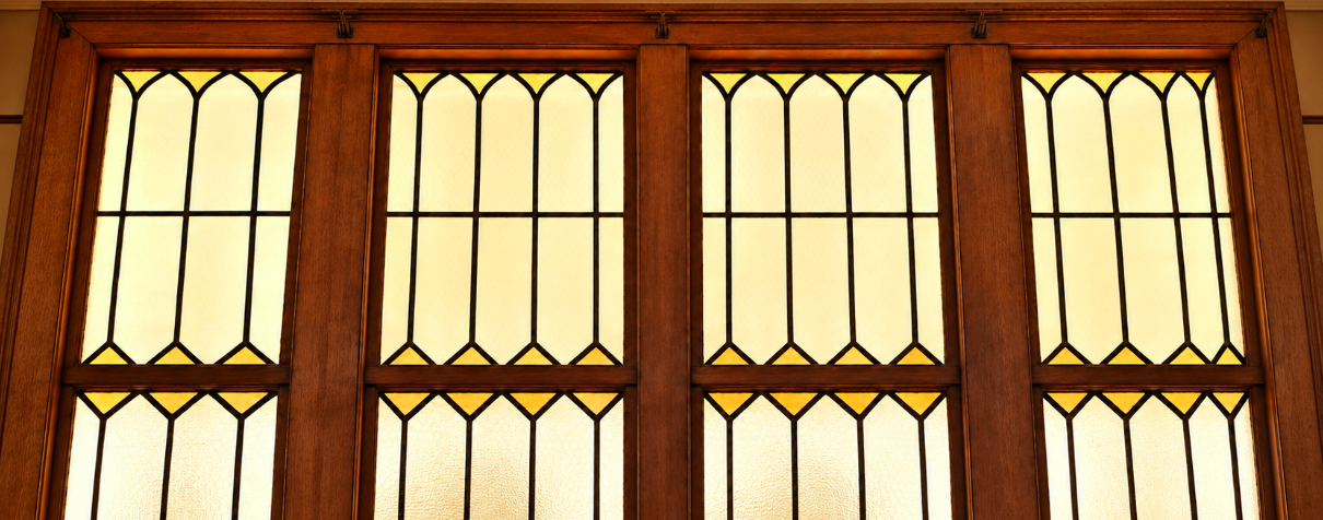 Restored red church doors with wrought iron hinges